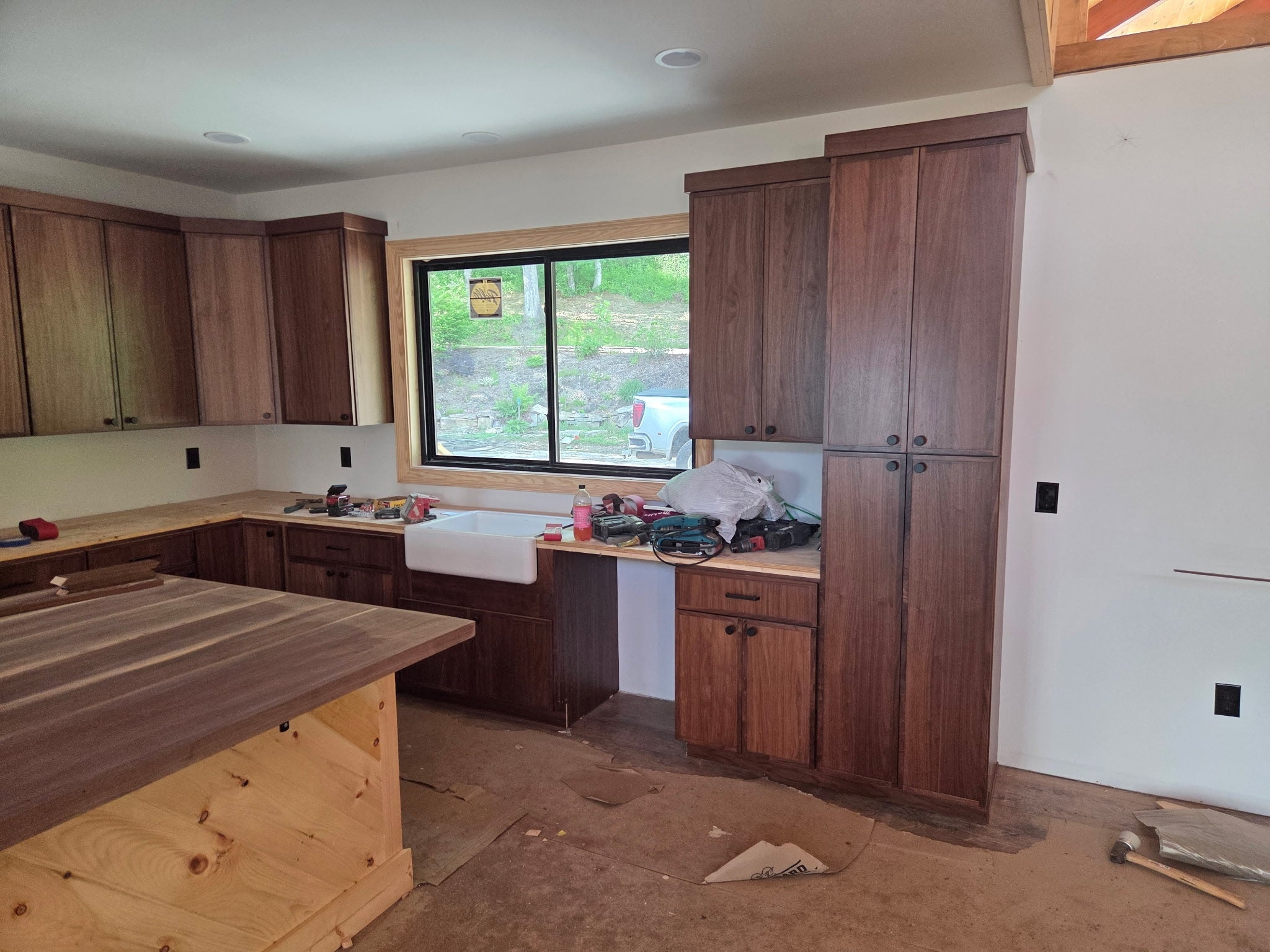 Custom walnut kitchen cabinets with farmhouse sink installed by Buchanan Kitchens & Tops in Western North Carolina