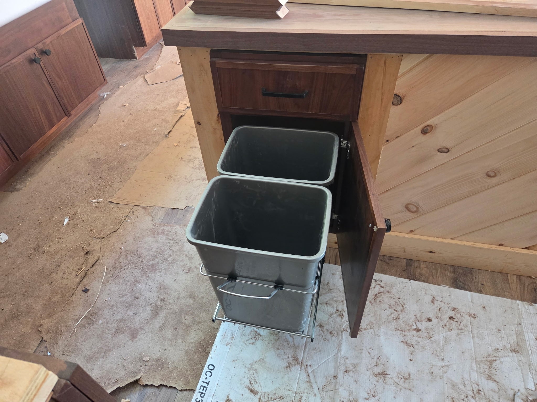 Walnut pantry cabinet with pull-out waste bins built by Buchanan Kitchens and Tops